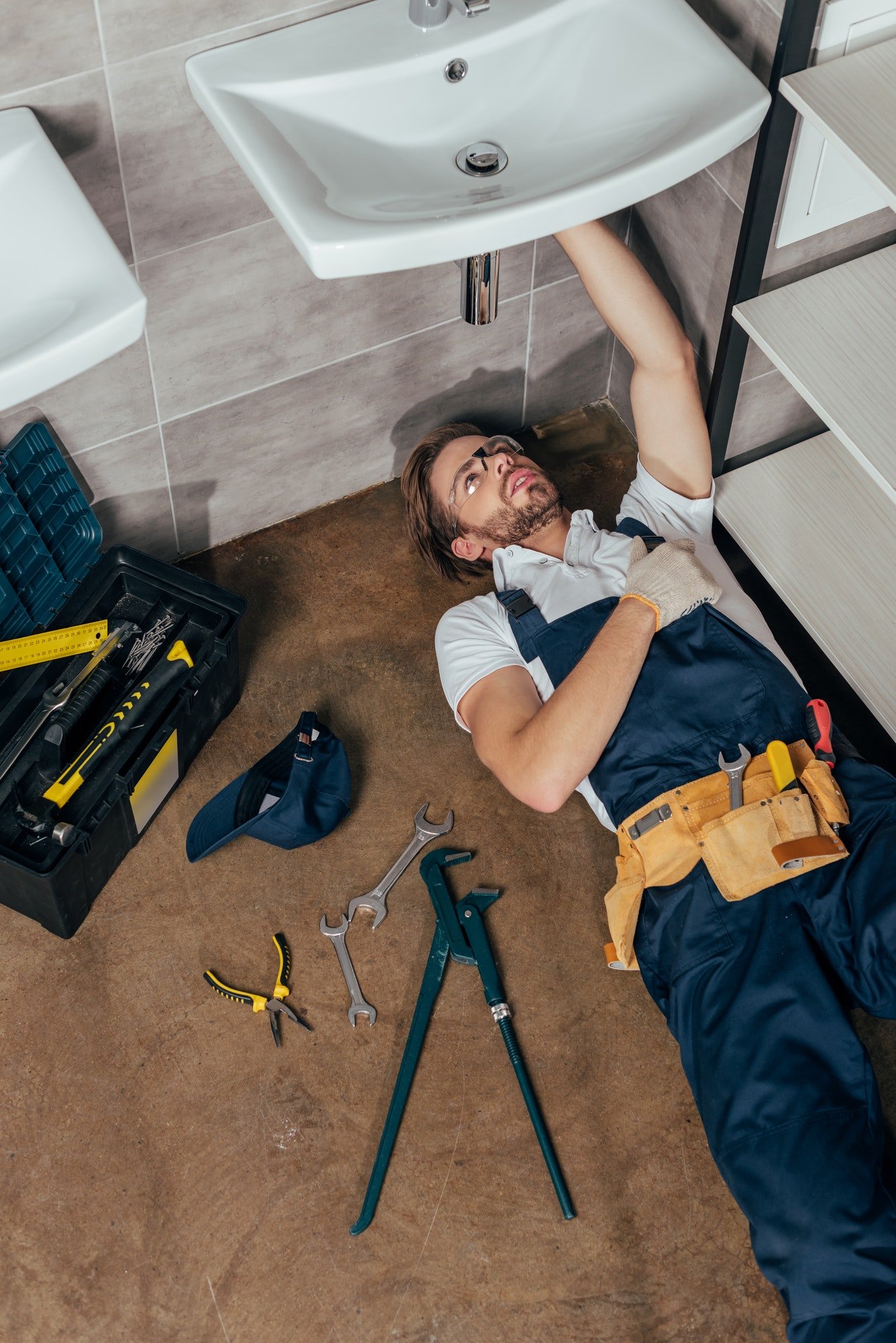 high-angle-view-of-young-male-plumber-fixing-sink-in-bathroom.jpg high-angle-view-of-young-male-plumber-fixing-sink-in-bathroom.jpg